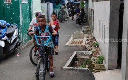 Viral: Kuburan di Gang Sempit Ibu Kota, Anak-anak Santai Bermain Sepeda di Sampingnya