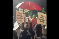 Hujan Deras Mengguyur KPU, Pendukung Ganjar Tetap Bertahan