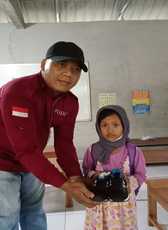 Guntur saat menyerahkan donasi sepatu./Istimewa-PGDCI