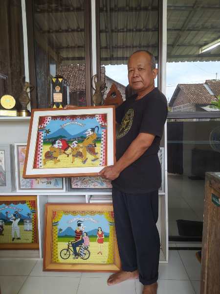 Subandi Giyanto menunjukkan karya lukis kaca miliknya./Harian Jogja-Sirojul Khafid